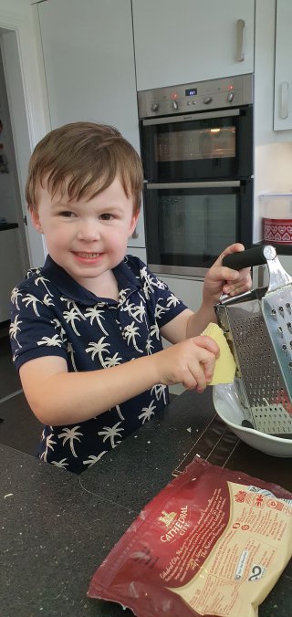 Grating_cheese_ethan_helping_cook_dinner_aug_2020